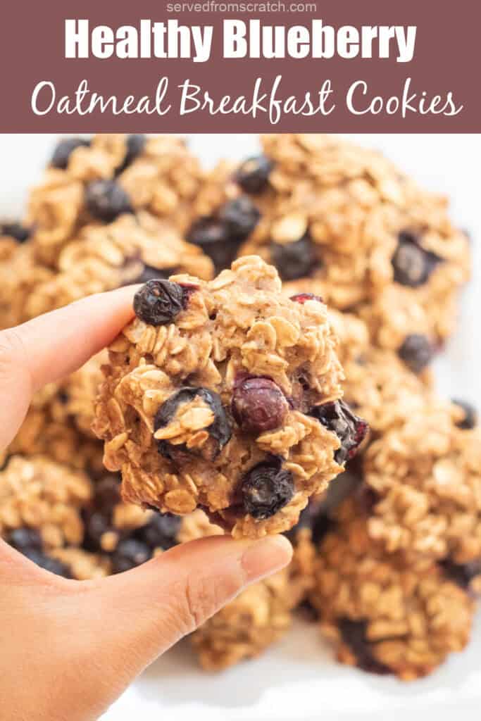 a hand holding an oatmeal cookie with blueberries and Pinterest pin text.