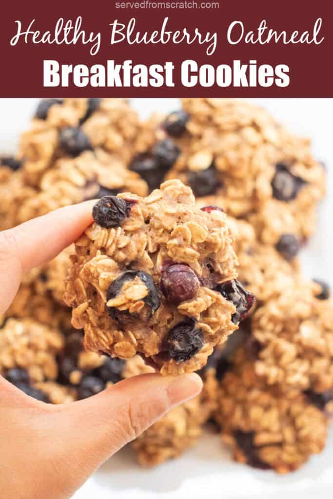 a hand holding an oatmeal cookie with blueberries and Pinterest pin text.