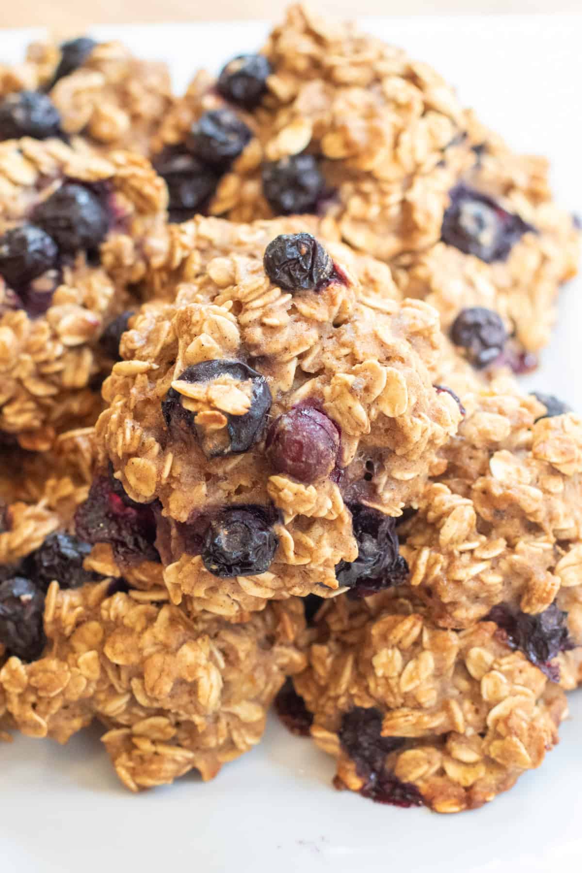 a close up of a plate of oatmeal cookies with blueberries.