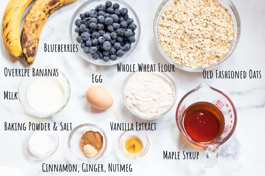 brown bananas, bowls of blueberries, oats, flour, egg, milk, spices, maple syrup, all labeled.