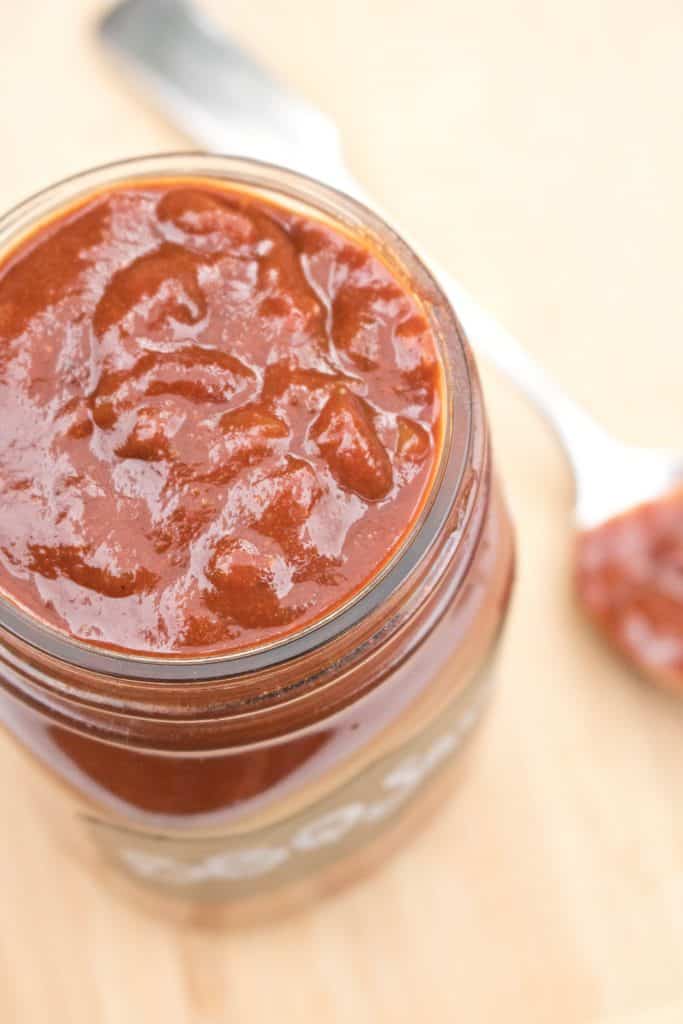 an open mason jar with bbq sauce.