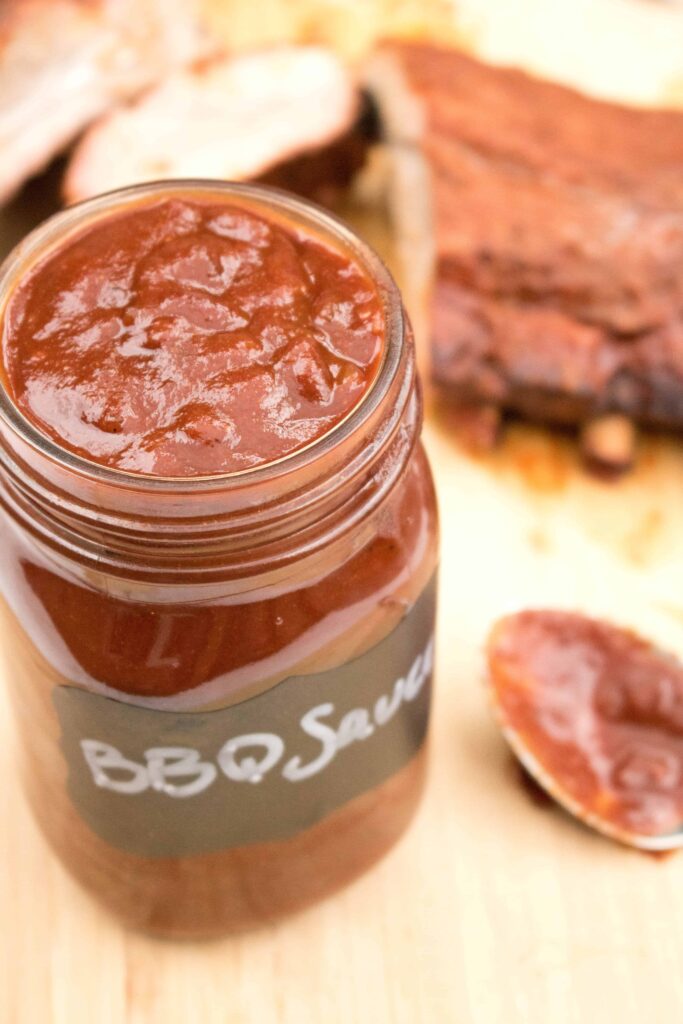 an open mason jar with bbq sauce.