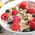 a bowl of muesli with fresh raspberries