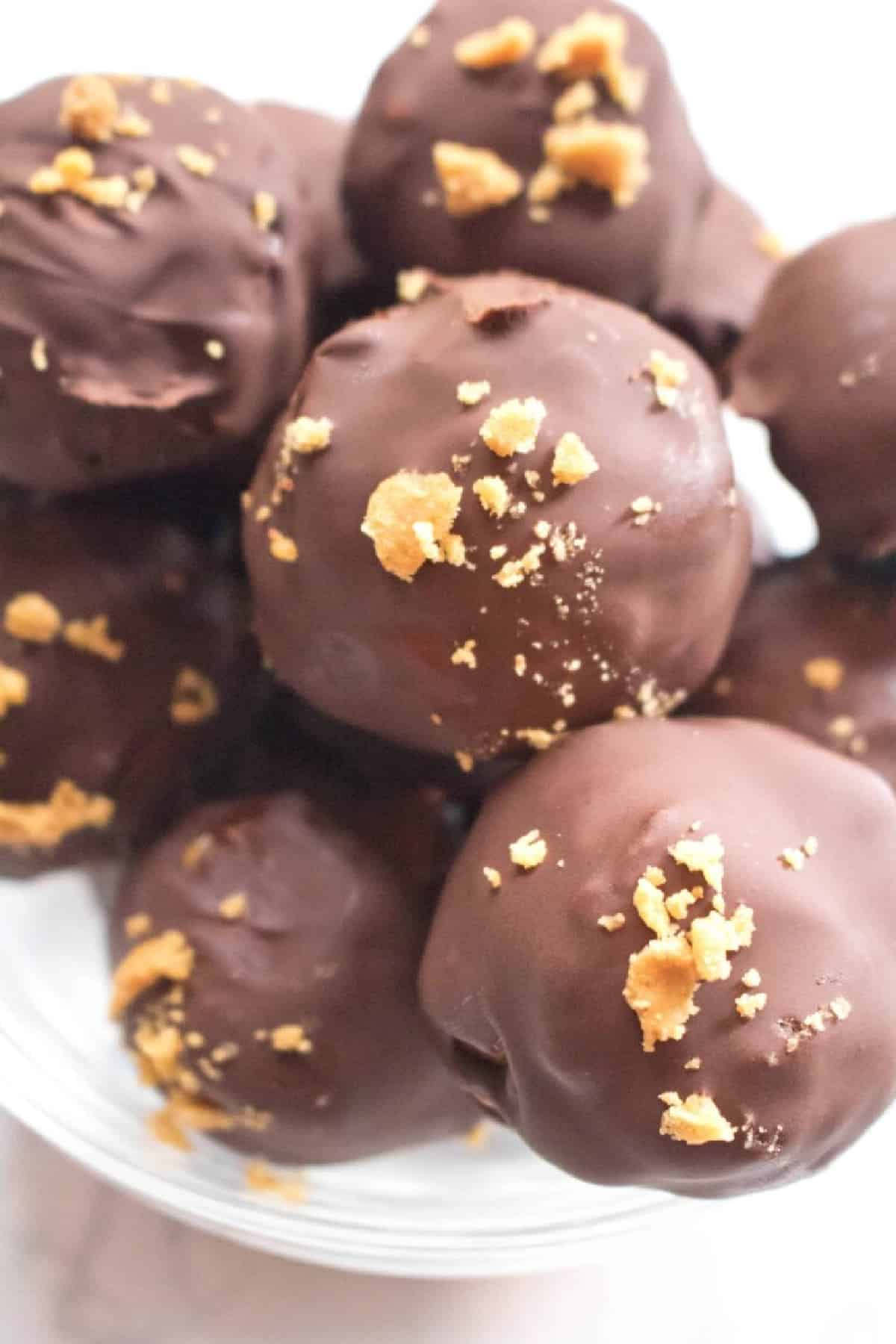 close up of a bowl of chocolate covered balls with crunchy topping.