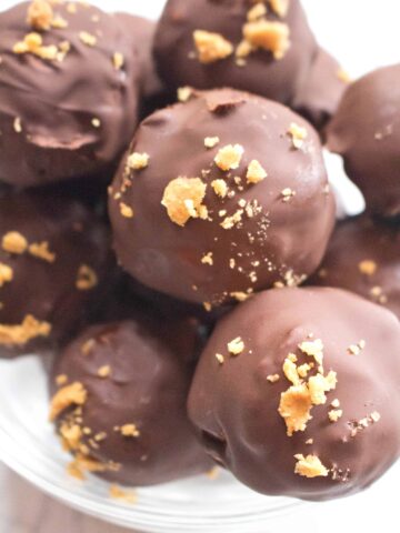 close up of a bowl of chocolate covered balls with crunchy topping