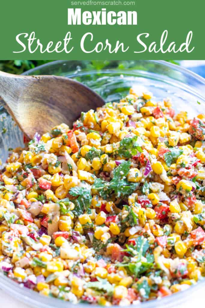 a big bowl of Mexican Street Corn Salad with a wooden spoon in it Mexican street corn salad.