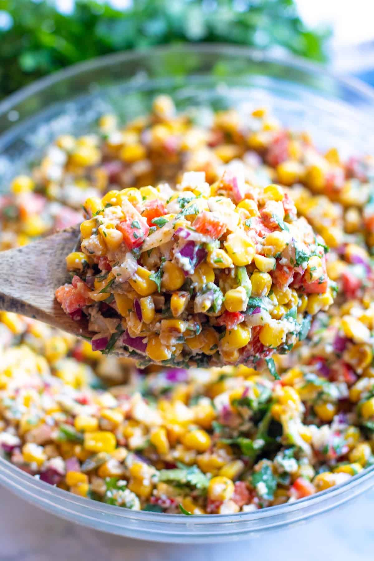 a spoon holding up some Mexican Street Corn Salad.