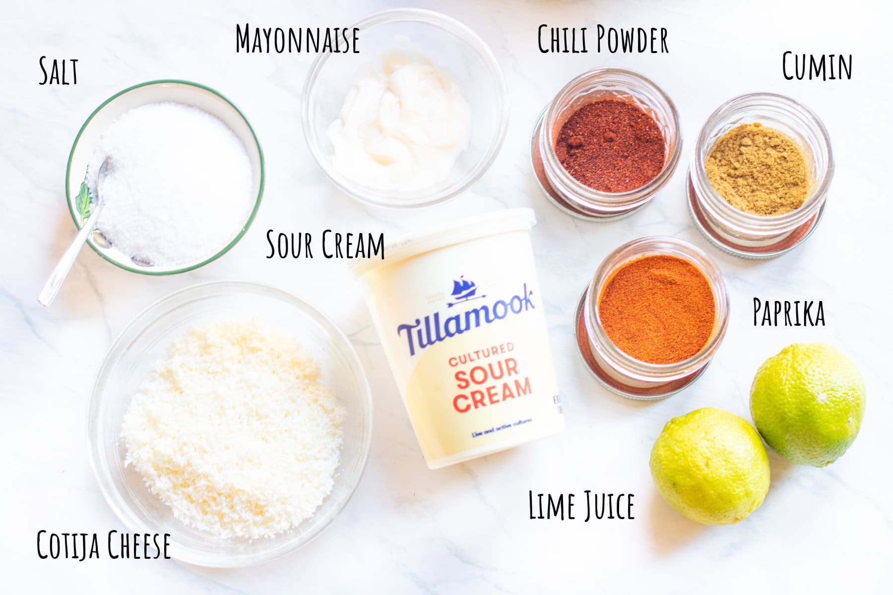 bowl of mayonnaise, salt, and cotija cheese, spices, lime, sour cream, all labeled.