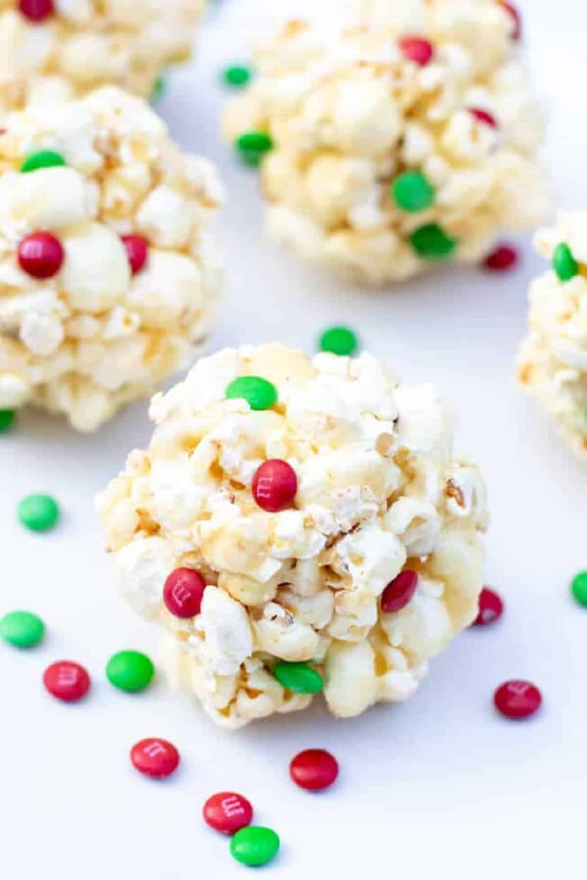 a close up of a popcorn ball with christmas colored m&ms.