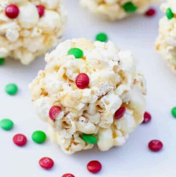 a close up of a popcorn ball with christmas colored m&ms.