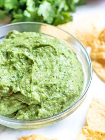 a bowl of avocado with chips on counter.