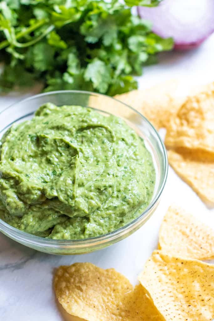 a bowl of fresh guacamole with chips 