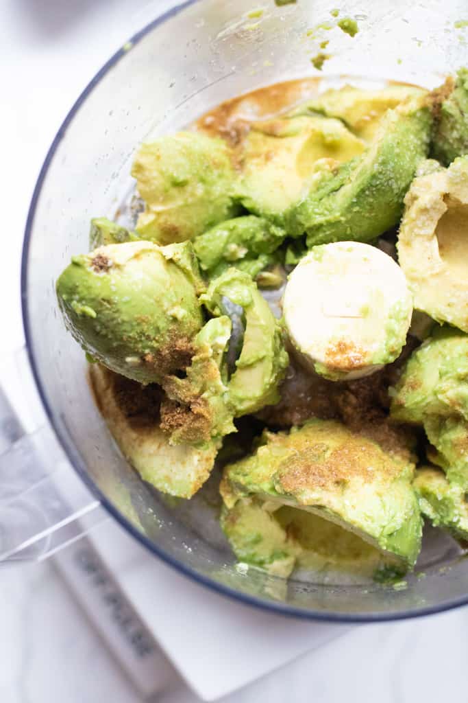 lots of avocados with cumin in a food processor 