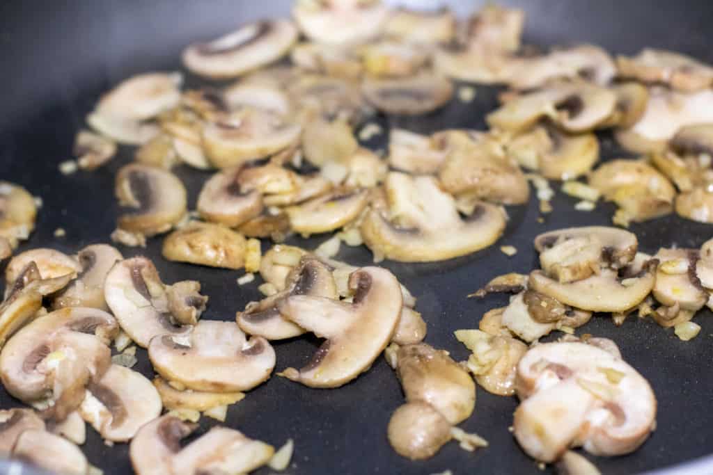 mushrooms and garlic sautéing in  pan
