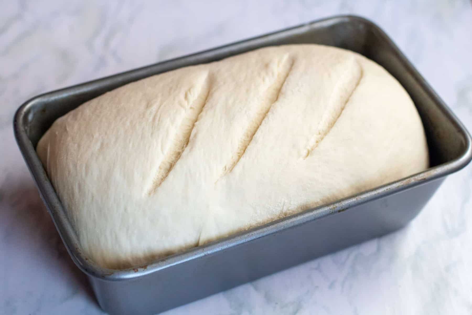 an unbaked loaf of bread in a loaf pan.