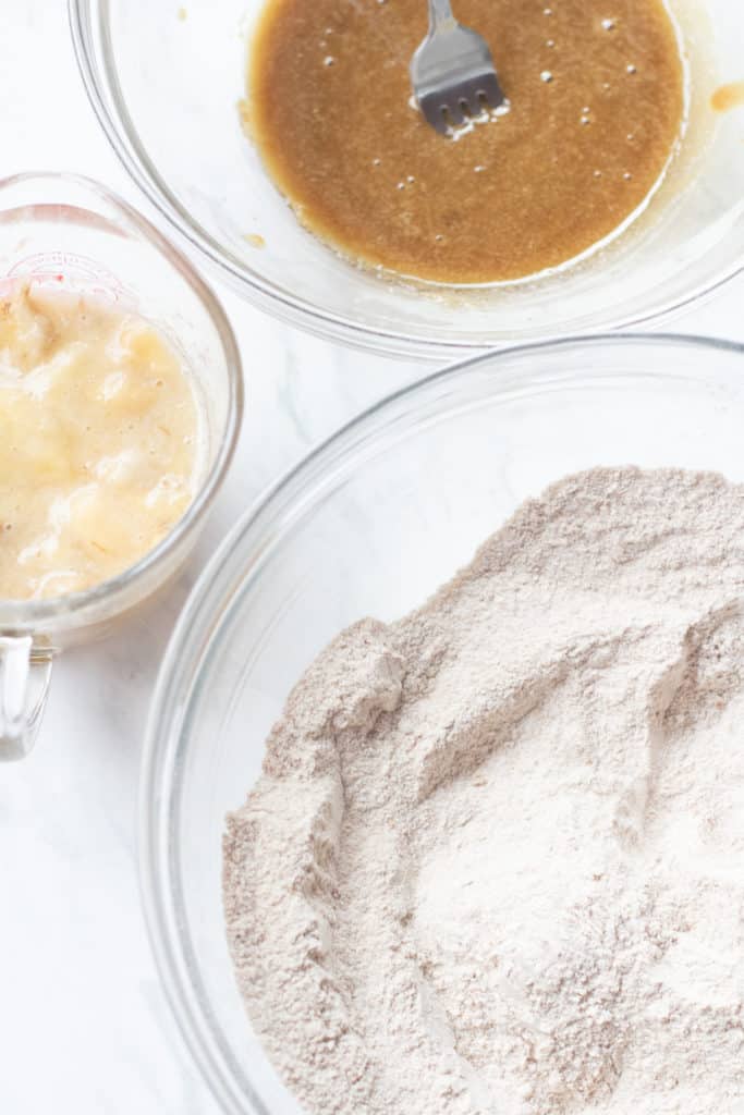 whole wheat flour mixture in bowl and mashed bananas and eggs in another bowl