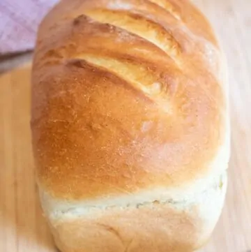 a loaf of white bread on a cutting board.