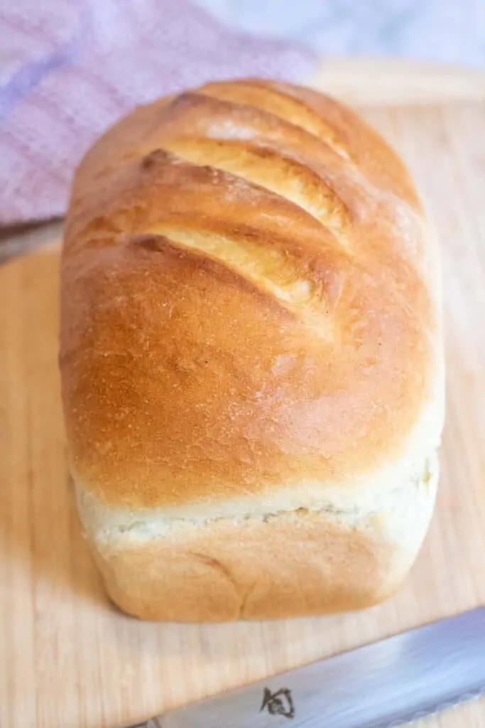 a loaf of white bread on a cutting board.