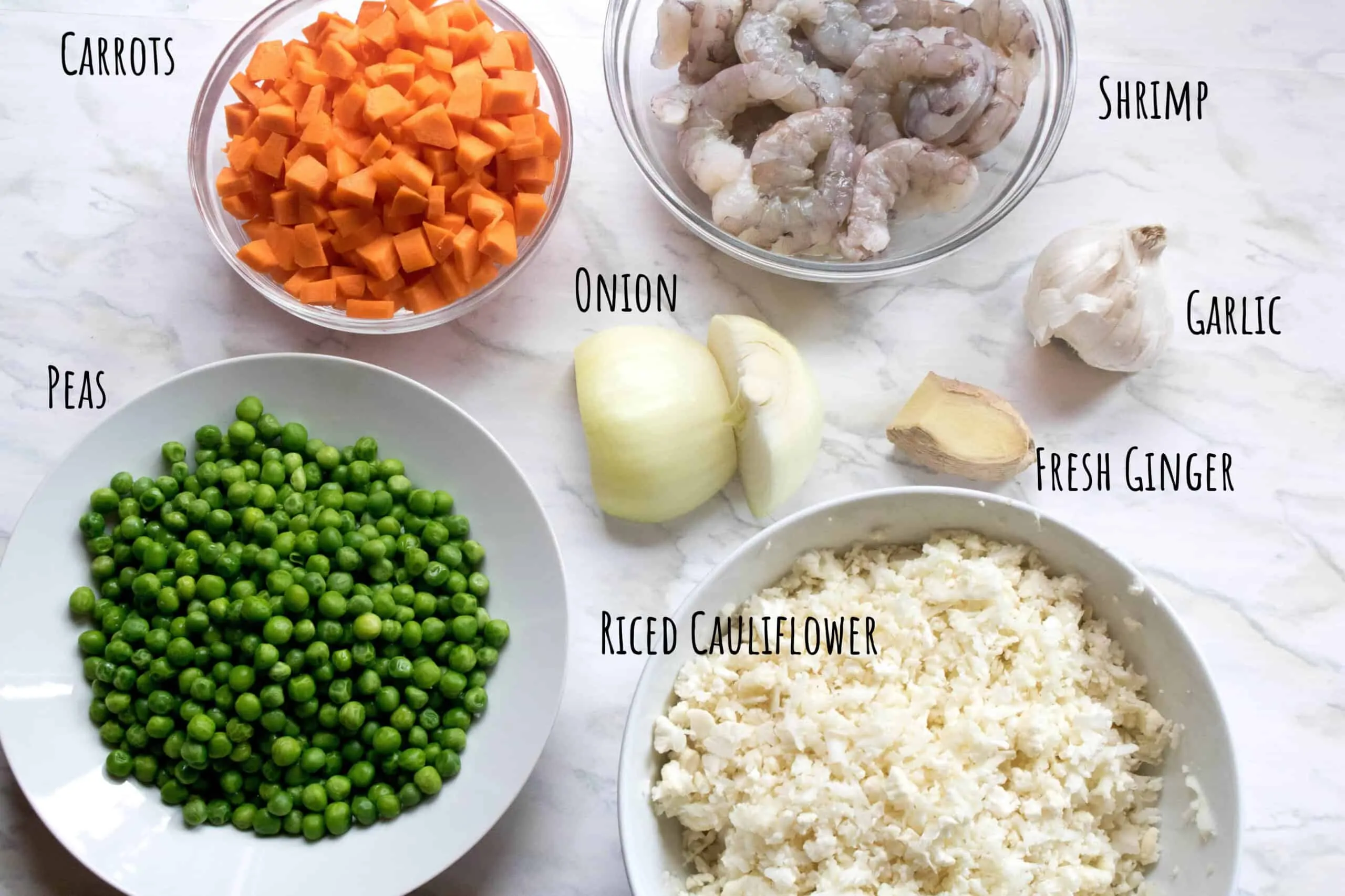 peas, carrots, onion, shrimp, garlic, and ginger and riced cauliflower on counter