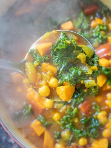 dutch oven of cooked chickpeas, sweet potato, kale soup.