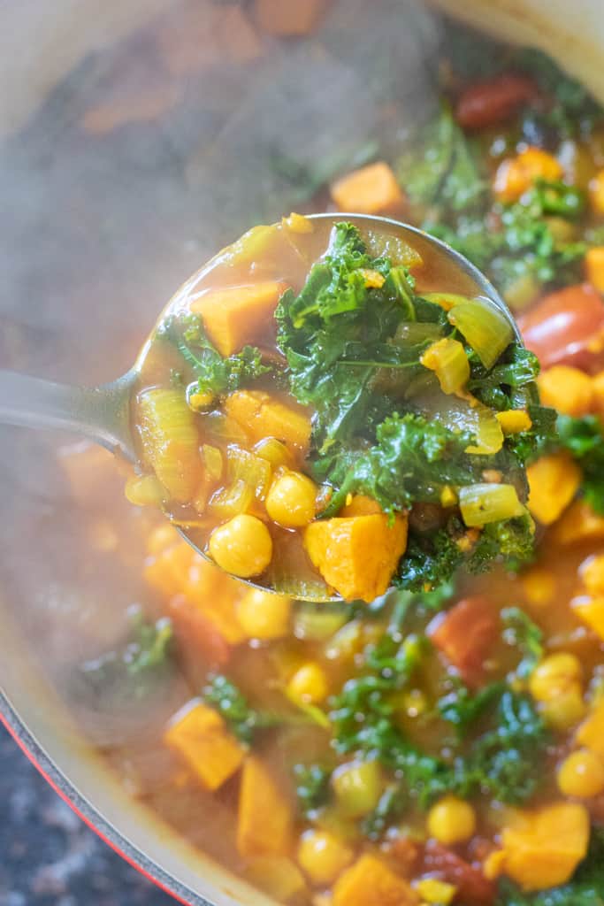 dutch oven of cooked chickpeas, sweet potato, kale soup.