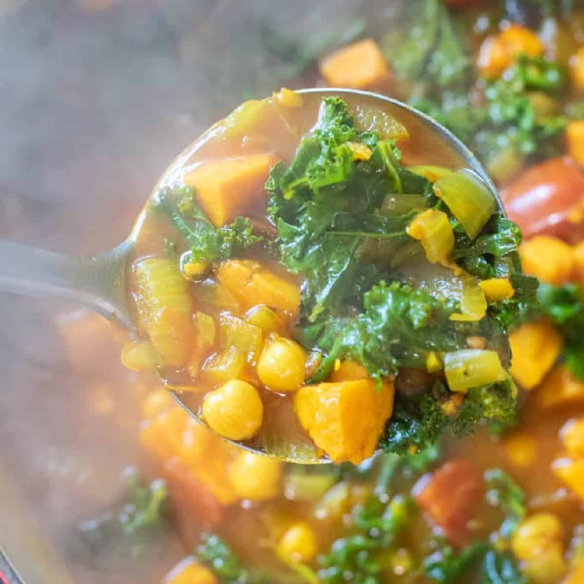 dutch oven of cooked chickpeas, sweet potato, kale soup.