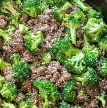 cooked ground beef and broccoli with sesame seeds in a cast iron.