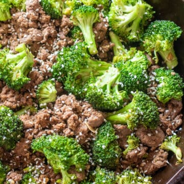 cooked ground beef and broccoli with sesame seeds in a cast iron.