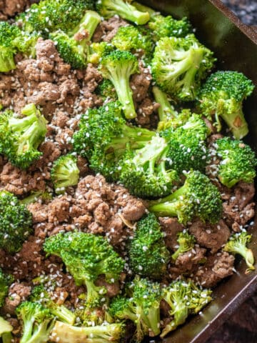 cooked ground beef and broccoli with sesame seeds in a cast iron.