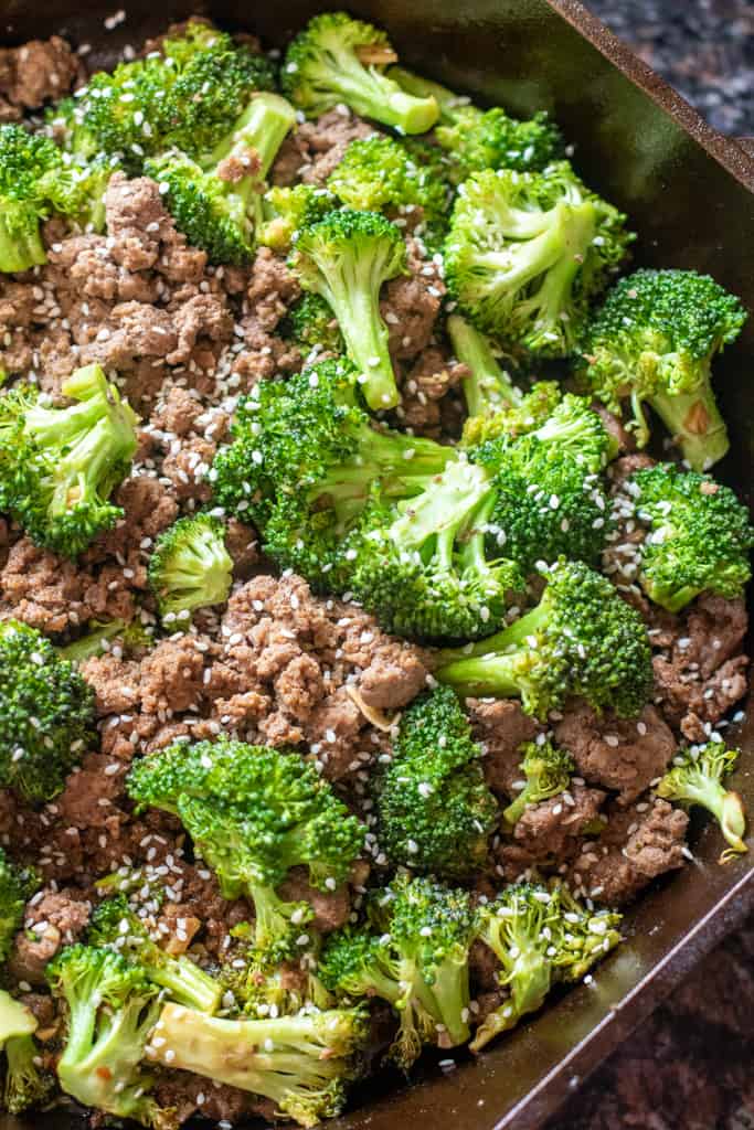 cooked ground beef and broccoli with sesame seeds in a cast iron.