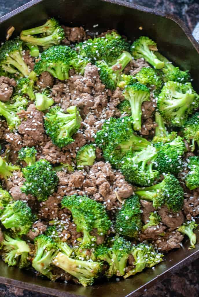 cooked ground beef and broccoli with sesame seeds in a cast iron.