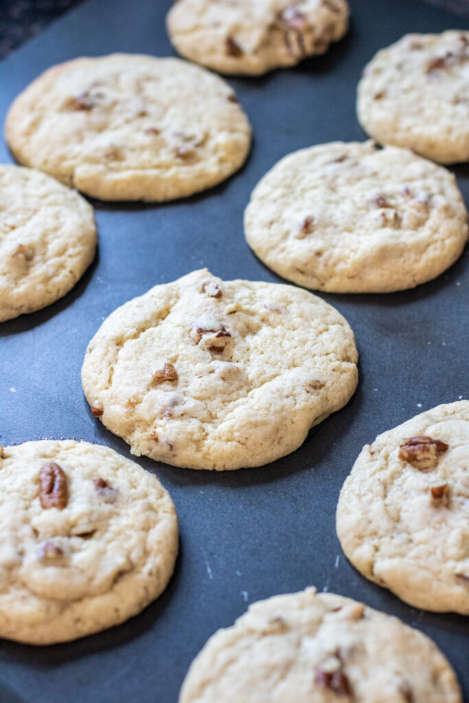 cooked pecan sandies on a cookie sheet