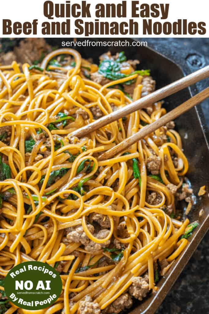 noodles in a cast iron with chopsticks spinach and beef.