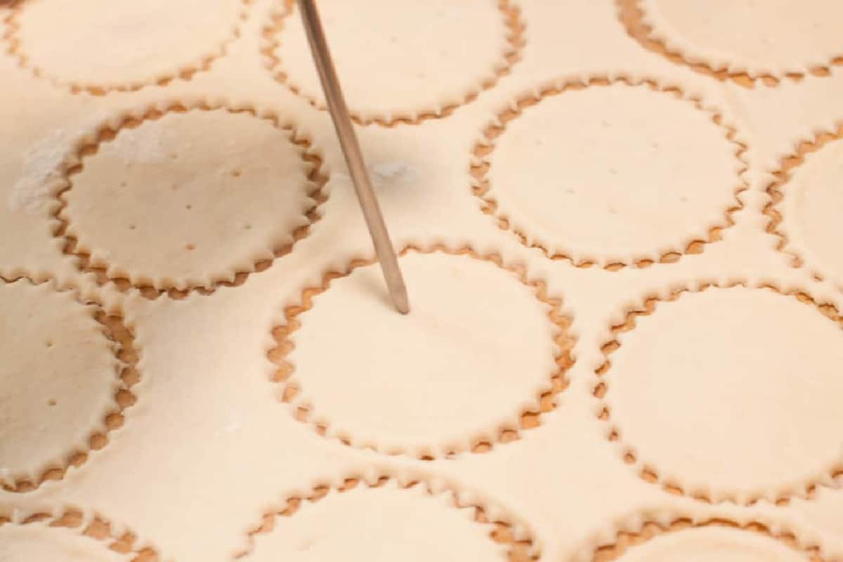 poking holes in circular dough.