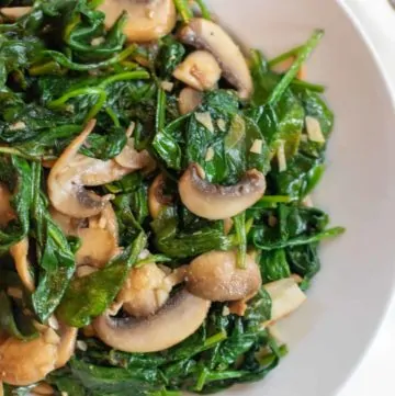 cooked spinach and mushrooms in a bowl.