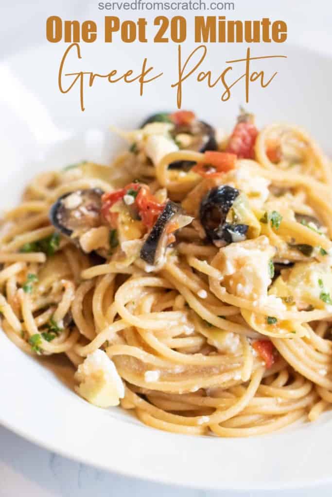 a plate of cooked pasta with olives and tomatoes and feta cheese with Pinterest pin text.