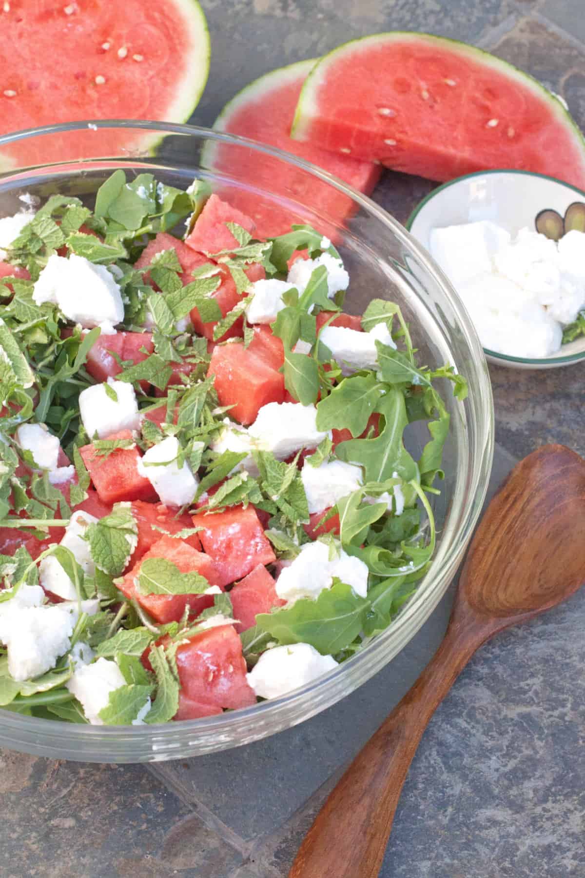a large bowl of watermelon arugula and feta.
