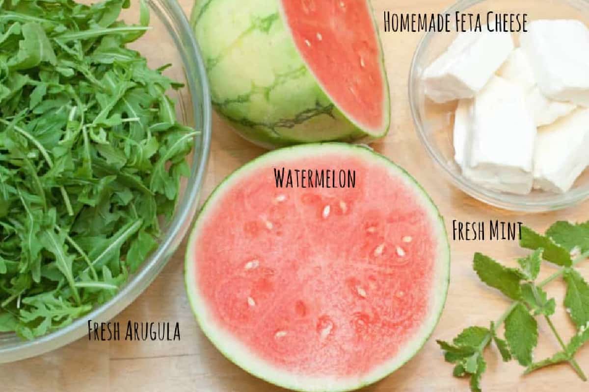 a bowl of arugula, watermelon, feta cheese, and mint.