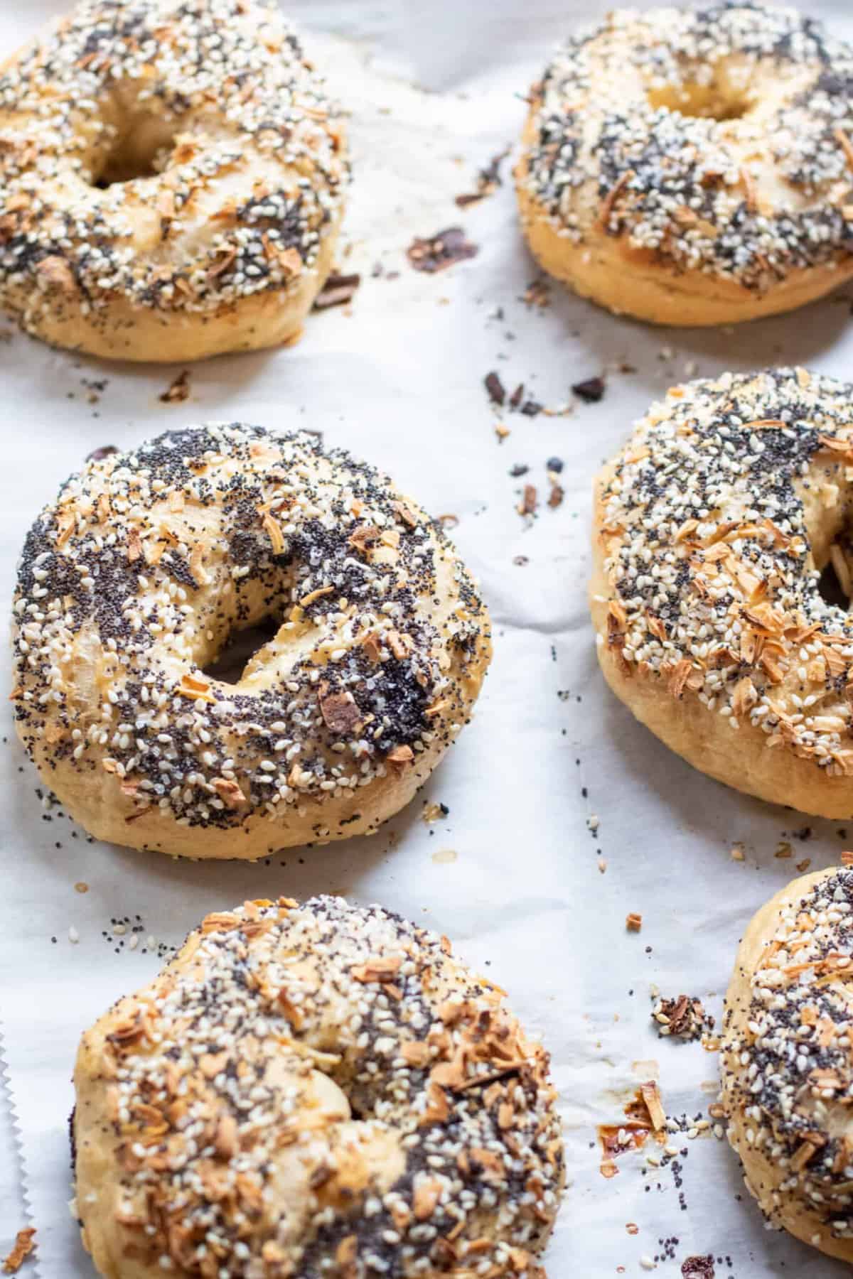 6 everything bagels on parchment lined baking sheets.