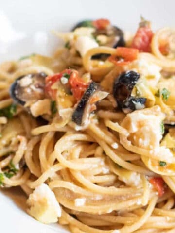 greek pasta with olive and tomatoes and feta cheesein a bowl.