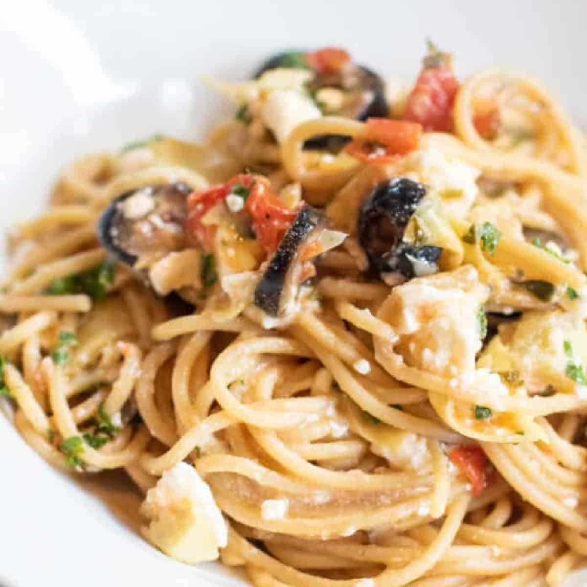 greek pasta with olive and tomatoes and feta cheesein a bowl.