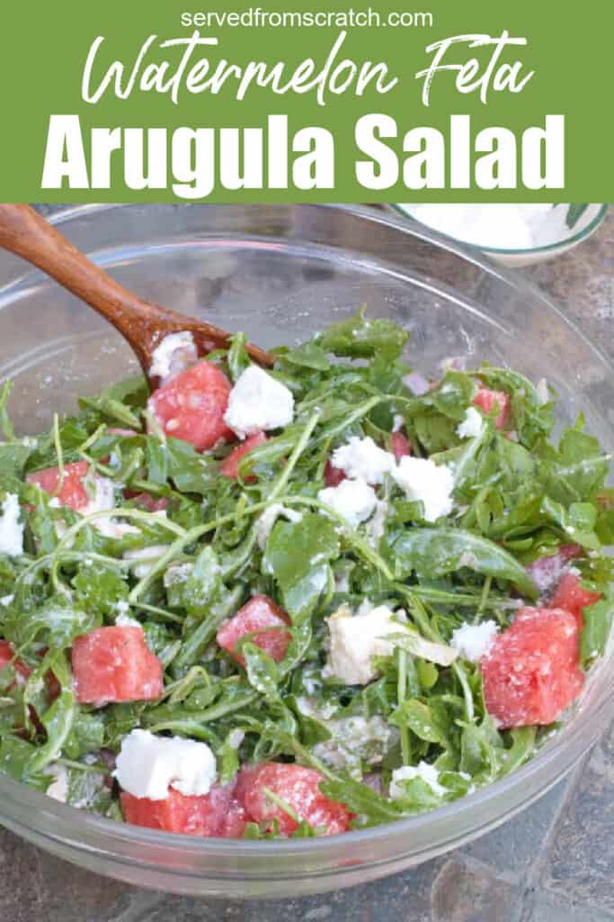 arugula watermelon feta salad in a large bowl with a wooden spoon with Pinterest pin text.