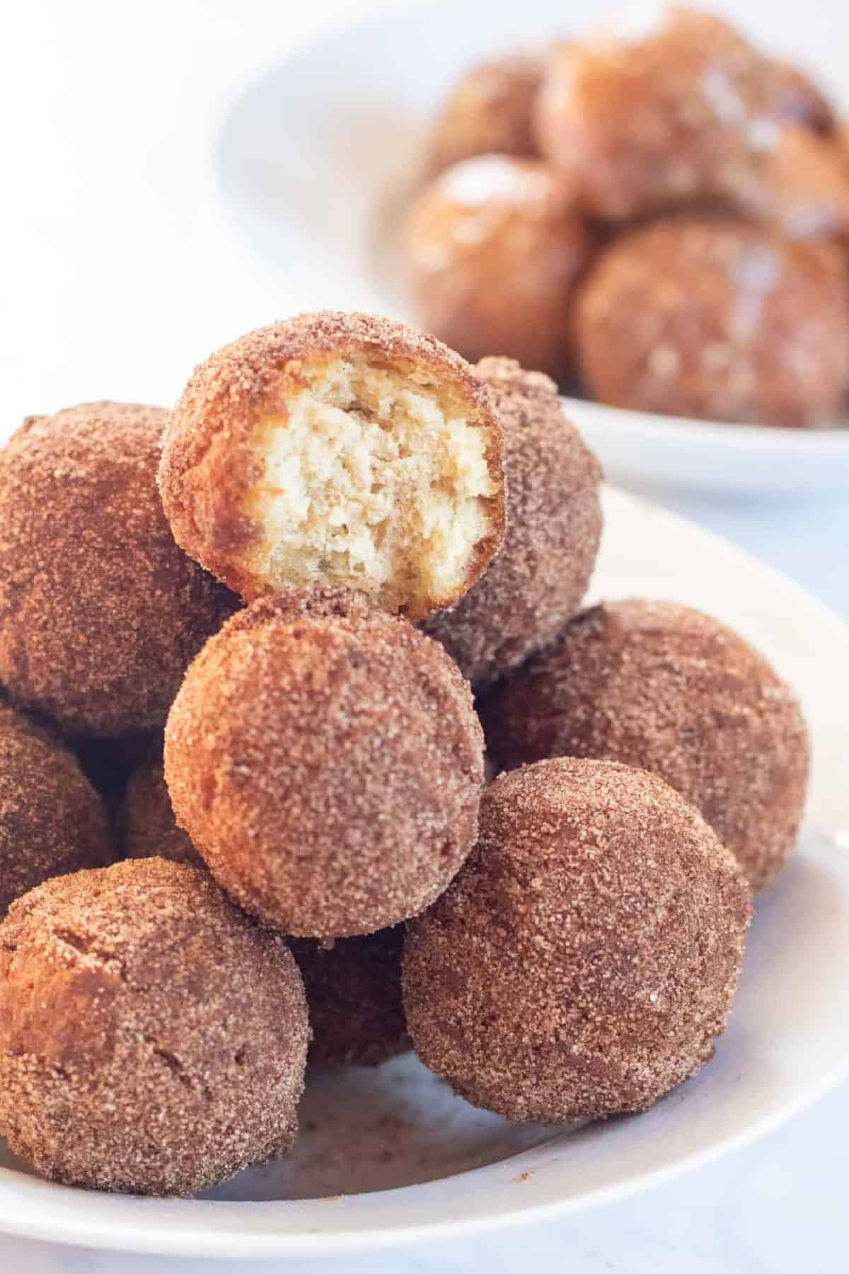 bowl of cinnamon sugar munchkins .with glazed munchkins in a bowl behind.