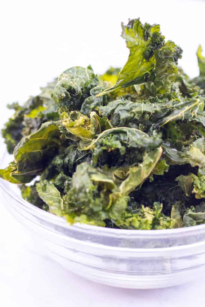 a bowl filled with crispy kale chips.