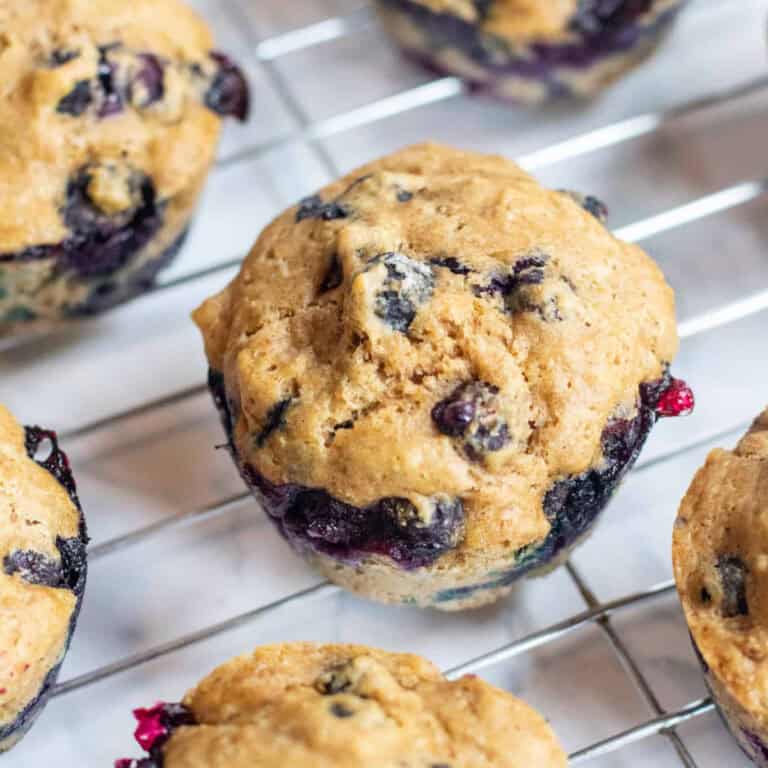 a cooling rack with blueberry muffins on it.