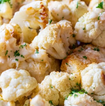 close up of cheesy roasted cauliflower on a plate.