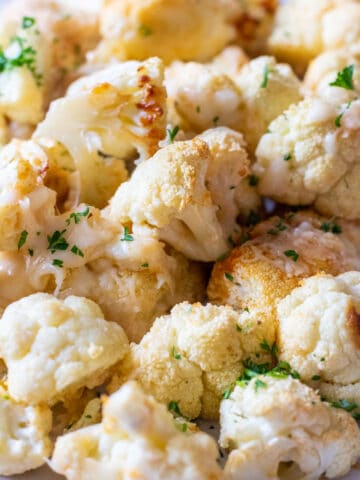 close up of cheesy roasted cauliflower on a plate.