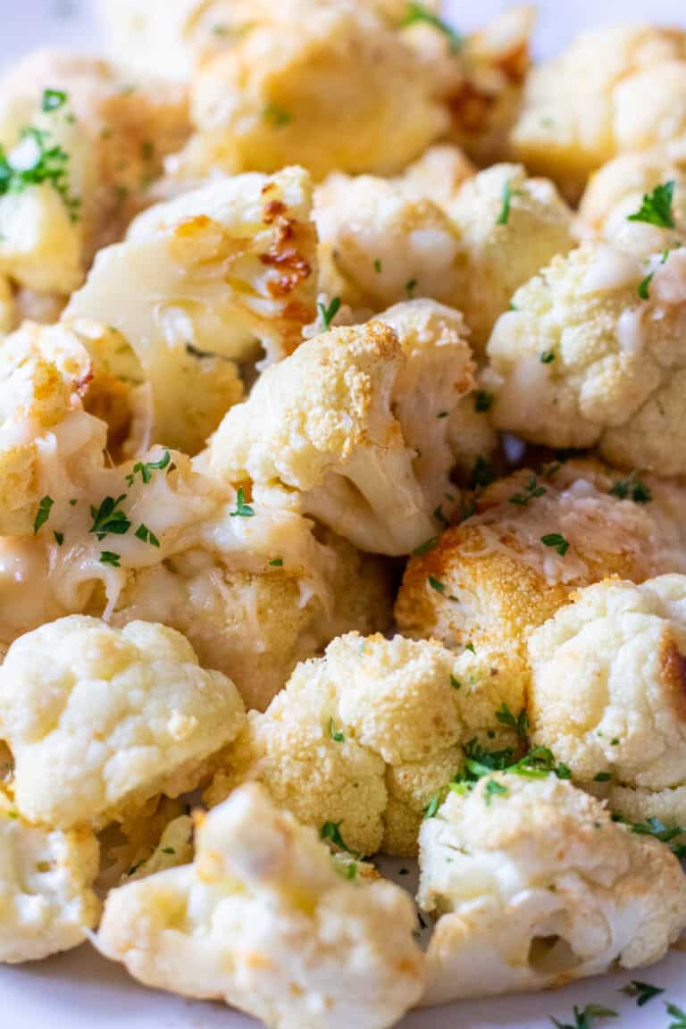 close up of cheesy roasted cauliflower on a plate.