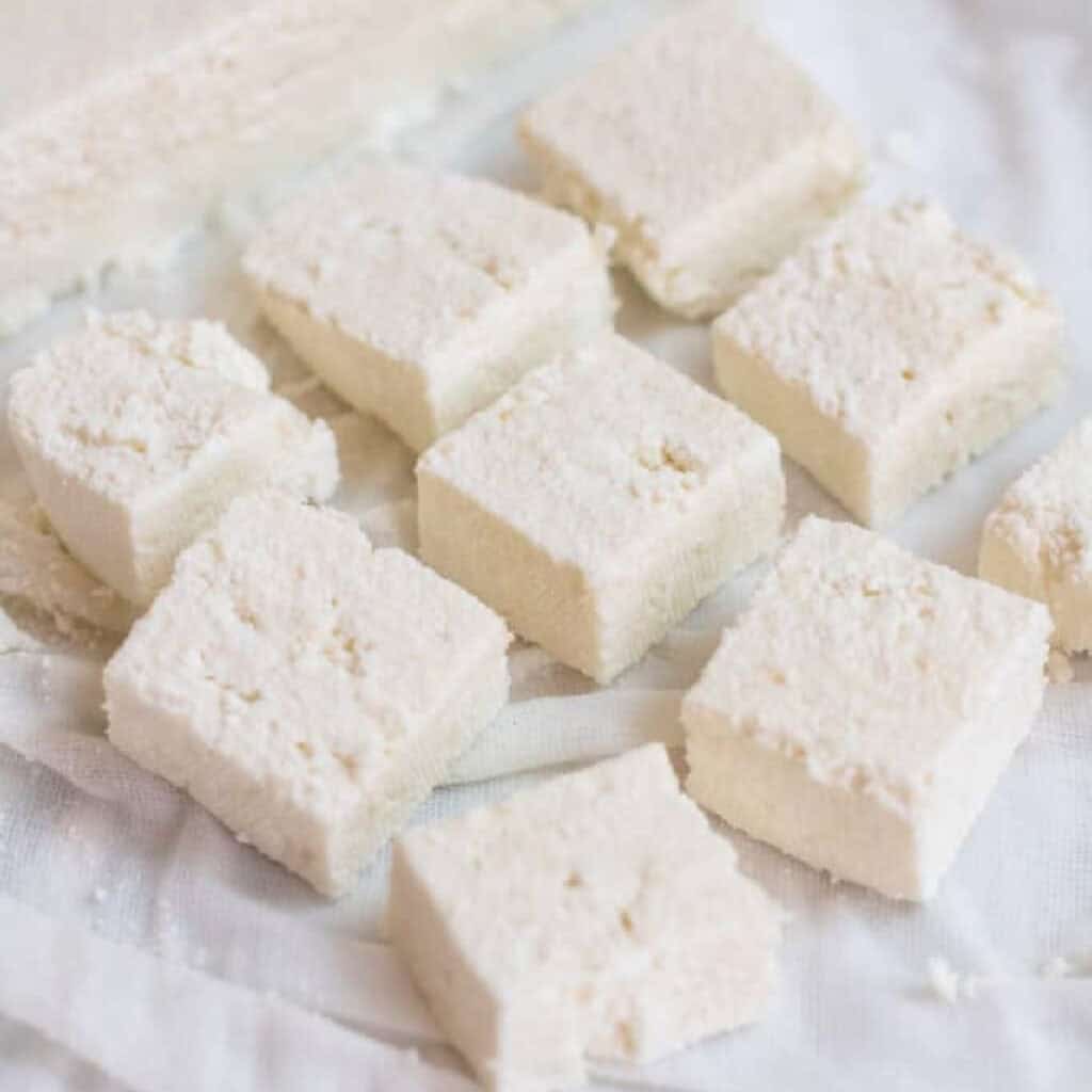 sliced and cut paneer in a cheesecloth.