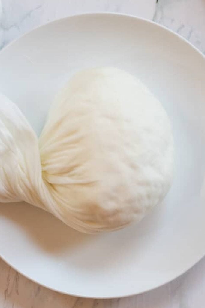 drained cheese in a cheesecloth.